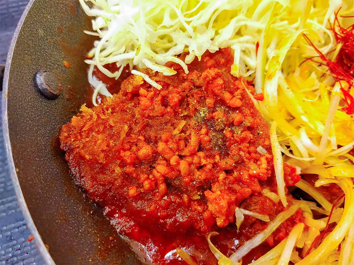 辛ダレに浸かり真っ赤に色付いたチキンカツ